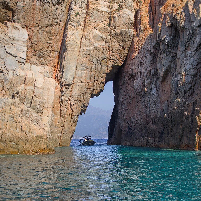 calanques de piana avec arche et bateau