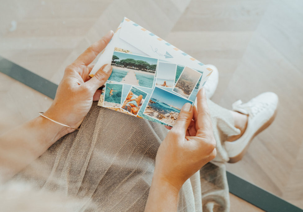 woman’s hands holding a summer card with sea