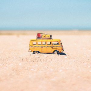 Gelber Kombi-Van im Sandurlaub am Meer